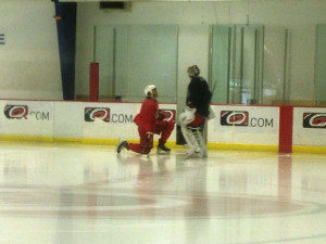 Kevin Westgarth stretches while talking with Cam Ward - Peter Koutroumpis, Triangle Sports Network